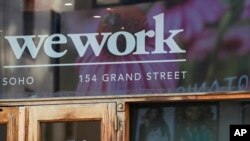 Logo WeWork di pintu masuk salah satu ruang kantor mereka di kawasan SoHo, New York, Selasa, 15 Oktober 2019. (AP/Mary Altaffer)