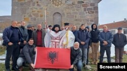 Samoproklamovani sveštenik Nikola Džufka sa grupom vernika i albanskom zastavom ispred crkve Svetog Arhangela Mihaila u albanskom selu Rakinici, u opštini Podujevo, 28. novembra 2023. 