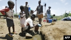 Wanawake na watoto wa Zimbabwe wakichota maji kutoka kwa kisima 