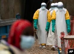 Petugas kesehatan yang mengenakan alat pelindung diri memulai giliran kerja mereka di pusat pengobatan Ebola di Beni, Kongo. (Foto: AP)