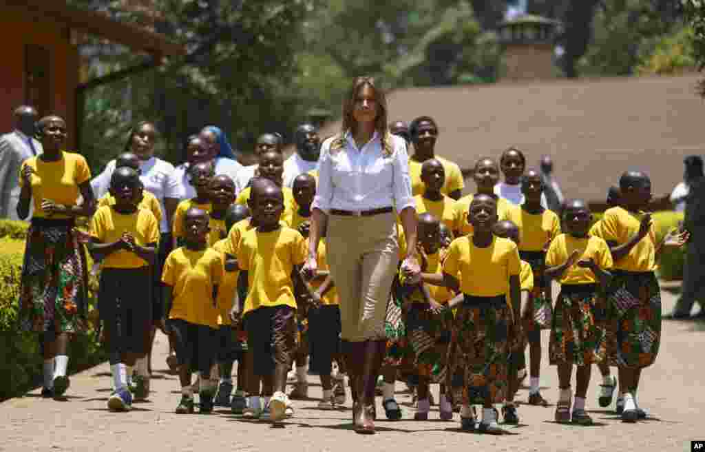 First lady Melania Trump walks with singing children as she visits the Nest Orphanage in Limuru, Kenya, Oct. 5, 2018.