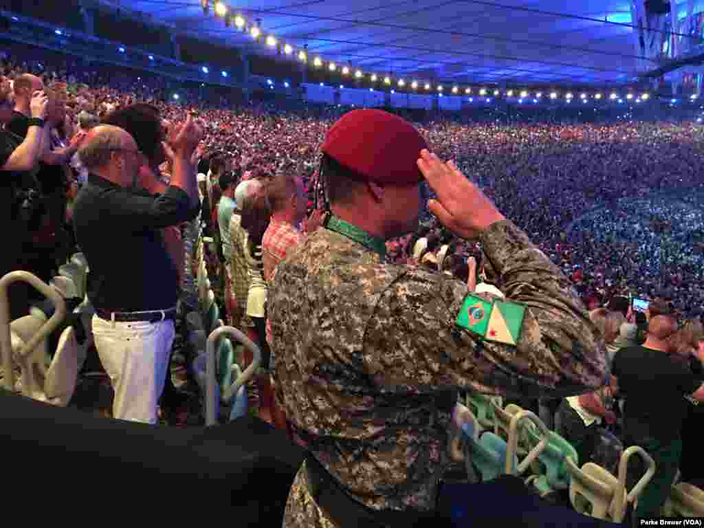 Seorang polisi militer memberi hormat saat lagu kebangsaan Brazil dimainkan pada awal upacara pembukaan Olimpiade Musim Panas 2016 di Stadion Maracana, Rio de Janeiro, Brazil (5/8).