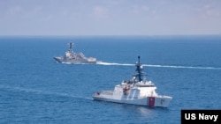 美国海军公布的图片显示美国海军“基德”号阿利·伯克级导弹驱逐舰与美国海岸警卫队“蒙罗”号传奇级巡逻舰在当地时间2021年8月27日例行穿越台湾海峡的国际水域。