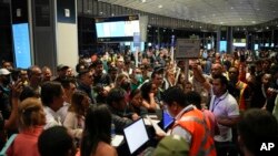 Wasafiri wakijaribu kubadilisha safari zao kufuatia kimbunga Ian, katika uwanja wa ndege wa kimataifa wa Tocumen, Panama City, Sept. 27, 2022.