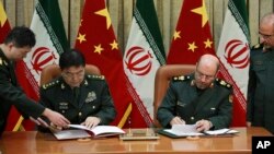 지난 14일 이란 테헤란에서 호세인인 데흐칸 이란 국방장관(오른쪽)과 장완취안 중국 국방부장이 군사방위협력 협정에 서명하고 있다.