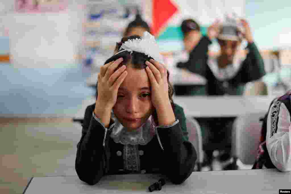 A classmate of Palestinian student Lian Al Shaer, 10, who was killed in recent Israel-Gaza fighting, reacts to Al Shaer's picture as a new school year begins, in Khan Younis in the southern Gaza Strip, Aug. 29, 2022.