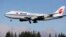 The Air China Boeing 747-400 plane carrying Chinese President Xi Jinping flies over a line of evergreen trees as it heads in to land, Sept. 22, 2015, at Boeing Field in Everett, Wash. 