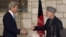 U.S. Secretary of State John Kerry (L) and Afghanistan's President Hamid Karzai shake hands at the end of their joint news conference at the presidential palace in Kabul, March 25, 2013. 