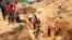 FILE - In this photograph taken on Apr. 4, 2018, gold miners work at a mining site in the Cameroon town of Betare Oya.
