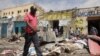FILE - Residents look at the scene of an al-Qaida-linked al-Shabab group militant attack, in Mogadishu, Somalia, Aug. 21, 2022. 