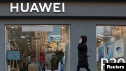 资料照：一名女子走过乌克兰首都基辅市中心的一家华为商店。（2019年11月11日, 路透社）