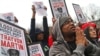 FILE - Demonstrators pray during the Million Hoodie March in Union Square, March 21, 2012, in New York. 