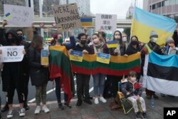 来自乌克兰和格鲁吉亚等东欧国家的旅台人士与台湾民众一起在莫斯科驻台北代表处的门外举牌抗议俄军入侵乌克兰。 (2022年2月25日)