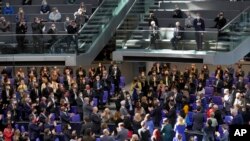 Ambasadori i Ukrainës Andrij Melnyk, qëndron në tribunën e vizitorëve, ndërsa ligjvënësit e duartrokasin në fillim të një takimi të parlamentit federal gjerman, Bundestag, në Berlin, Gjermani, të dielën, 27 shkurt 2022. (AP Photo/Michael Sohn)