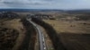 Cars line up on the road to the Shehyni border crossing as people flee to Poland, after Russia launched a massive military operation against Ukraine, outside Mostyska, Ukraine, Feb. 27, 2022.
