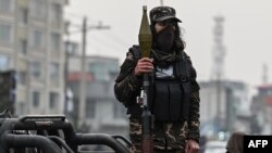 资料照：2022年1月21日，在喀布尔，一名塔利班战士手持火箭推进榴弹站在一辆车上。