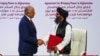 FILE -Mullah Abdul Ghani Baradar, the leader of the Taliban delegation, and Zalmay Khalilzad, U.S. envoy for peace in Afghanistan, shake hands after signing an agreement between members of Afghanistan's Taliban and the U.S., in Doha, Qatar, Feb. 29, 2020.