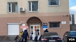 现在，每小时都有更多的撤离者出现在市中心，他们拉着轮子，艰难地背着鼓鼓的背包。他们来到市中心，看看能不能找到住处（美国之音德特默拍摄）。