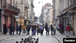 资料照：在俄罗斯总统普京授权对乌克兰东部开展军事行动后，人们在乌克兰利沃夫的一个取款机前排队。
