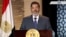 In this image taken from Egypt State TV, newly-elect President Mohammed Morsi delivers a speech in Cairo, Egypt, Sunday, June 24, 2012. In his first televised speech on state TV, Morsi pledged Sunday to preserve Egypt's international accords, a reference