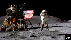 资料照片:美国宇航员约翰·扬（John Young）1972年4月在月球表面向美国国旗敬礼。