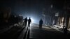 FILE - A group of men walk down a street without electricity late in the besieged rebel bastion of Douma, northeast of the Syrian capital Damascus on Nov. 10, 2014.