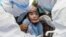 A child reacts to a throat swab during mass testing for COVID-19 in Wuhan