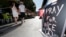 A couple walk through the empty flower market in the old city and near a sign which reads, "Pray for Nice" days after a truck attack on the Promenade des Anglais on Bastille Day killed scores and injured as many in Nice, France, July 17, 2016. 