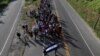 Central American migrants, part of a caravan trying to reach the U.S., walk along the road as they continue their journey, in Ciudad Hidalgo, Mexico, Oct. 26, 2018. 