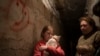 Elizabeth, 12, berlindung bersama kucing dan keluarganya di ruang bawah tanah di sebuah apartemen di Lyman, Ukraina, pada 26 April 2022. (Foto: AP/Leo Correa)