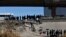FILE - Migrants wait to get into a U.S. government bus after crossing the border from Ciudad Juarez, Mexico, to El Paso, Texas, Dec. 12, 2022. Many migrants come to the U.S. border because of deteriorating economic and political conditions in their homelands.