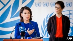 在联合国人权理事会在联合国日内瓦总部就伊朗局势召开特别会议期间，德国外长贝尔伯克与冰岛外长吉尔法多蒂尔站在一起，回答记者提问。(2022年11月24日)