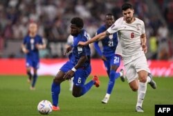 FILE - Iran's midfielder Saeid Ezatolahi, right, fights for the ball with USA's midfielder Yunus Musah during the Qatar 2022 World Cup Group B football match between Iran and USA at the Al-Thumama Stadium in Doha, Nov. 29, 2022.