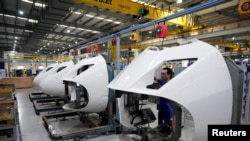 资料照：上海一家工厂的工人在高铁火车配件生产线上。（2022年7月21日）