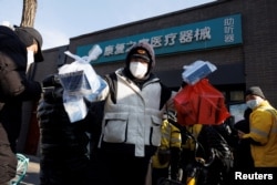 药房外排大队，北京快递小哥在药房取药后准备递送。（2022年12月7日）