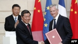 资料照：中国发改委主任何立峰与法国经济与财政部长布鲁诺·勒梅尔（右）在巴黎爱丽舍宫签署协议后，中国领导人习近平为其鼓掌。（2019年3月25日）