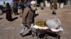 FILE - An Afghan man carries food supplies in a wheelbarrow during a distribution of humanitarian aid for families in need, in Kabul, Afghanistan, Feb. 16, 2022. 