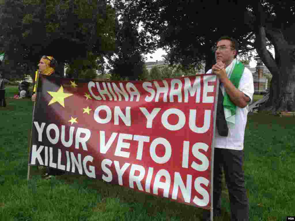 抗议人士展示谴责中国否决联合国决议的标语。