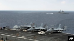 参加在印度南部港口金奈附近海域举行的印美日联合军演的美国“西奥多·罗斯福”号航空母舰。附近为美国海军"诺曼底"号导弹巡洋舰。（2015年10月17日）