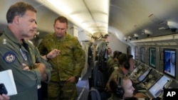 印太美军司令约翰∙阿奎利诺（左）海军上将在一架P-8A“波塞冬”侦察机查看南中国海局势最新发展。 (美联社2022年3月20日)