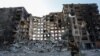 A service member of pro-Russian troops walks near an apartment building destroyed in the course of Ukraine-Russia conflict in the besieged southern port city of Mariupol, Ukraine, March 28, 2022.