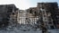 A service member of pro-Russian troops walks near an apartment building destroyed in the course of Ukraine-Russia conflict in the besieged southern port city of Mariupol, Ukraine, March 28, 2022.