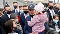 ប្រធានាធិបតី​សហរដ្ឋ​អាមេរិក លោក Joe Biden ពរ​ក្មេងស្រី​ម្នាក់​ នៅ​ពេល​លោក​ធ្វើ​ទស្សនកិច្ច​ទៅជួប​ជនភៀសខ្លួន​អ៊ុយក្រែន​នៅ​ពហុកីឡដ្ឋាន the PGE National Stadium ក្នុង​ទីក្រុង Warsaw ប្រទេស​ប៉ូឡូញ ថ្ងៃទី២៦ ខែមីនា ឆ្នាំ២០២២។ REUTERS/Evelyn Hockstein