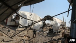 一名男子在加沙地带汗尤尼斯一处一天前被以色列空袭的地点查看现场。（2018年5月30日）