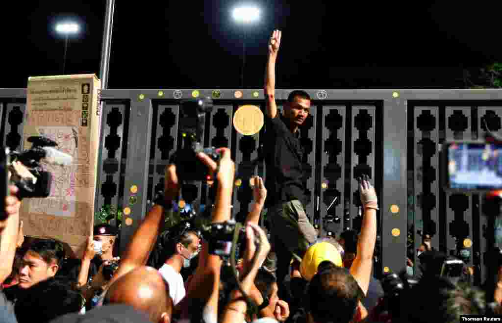 태국 방콕에서 쁘리윳 짠오차 총리의 축출과 군주제도 개혁을 요구하는 민주화 시위가 열리는 가운데 한 시위자가 &#39;이 나라는 국민의 것&#39;이란 문구가 적힌 금색 스티커를 의회 정문에 붙였다. 