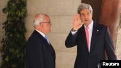 Menlu AS John Kerry (kanan) melambaikan tangannya disebelah juru runding Palestina Saeb Erekat sebelum bertemu dengan Presiden Palestina Mahmoud Abbas di Ramallah (23/5).