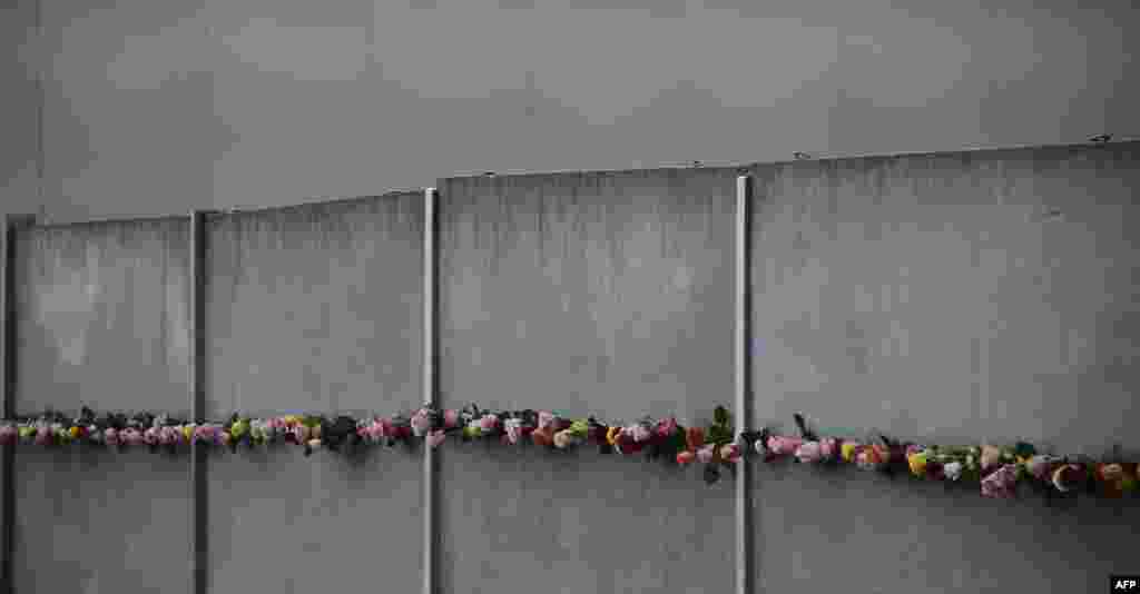 Bunga-bunga dipasang di tembok Berlin pada peringatan HUT ke-27 runtuhnya Tembok Berlin di Jerman.
