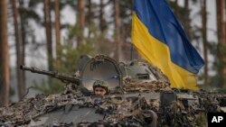 Des troupes ukrainiennes dans un véhicule blindé avancent à l'extérieur de Kiev, en Ukraine, le 31 mars 2022.