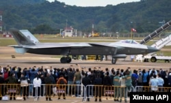 在第14届珠海航空航天展览会上，中国制造的歼-20重型隐身战斗机停在跑道上供参观者拍照。（2022年11月8日）