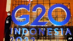一名保安站在二十国联合峰会峰的巨大招牌旁，二十国卫生和财政部长即将在印尼巴厘岛参加这次峰会有关健康、可持续能源及数码转变加的讨论，然而俄乌冲突、美中与西方国家日益紧张的关系或将始终是这次会议挥之不去的阴影。